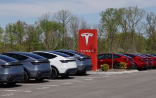 Tesla Model 3 and Tesla Model Y next to a Tesla logo