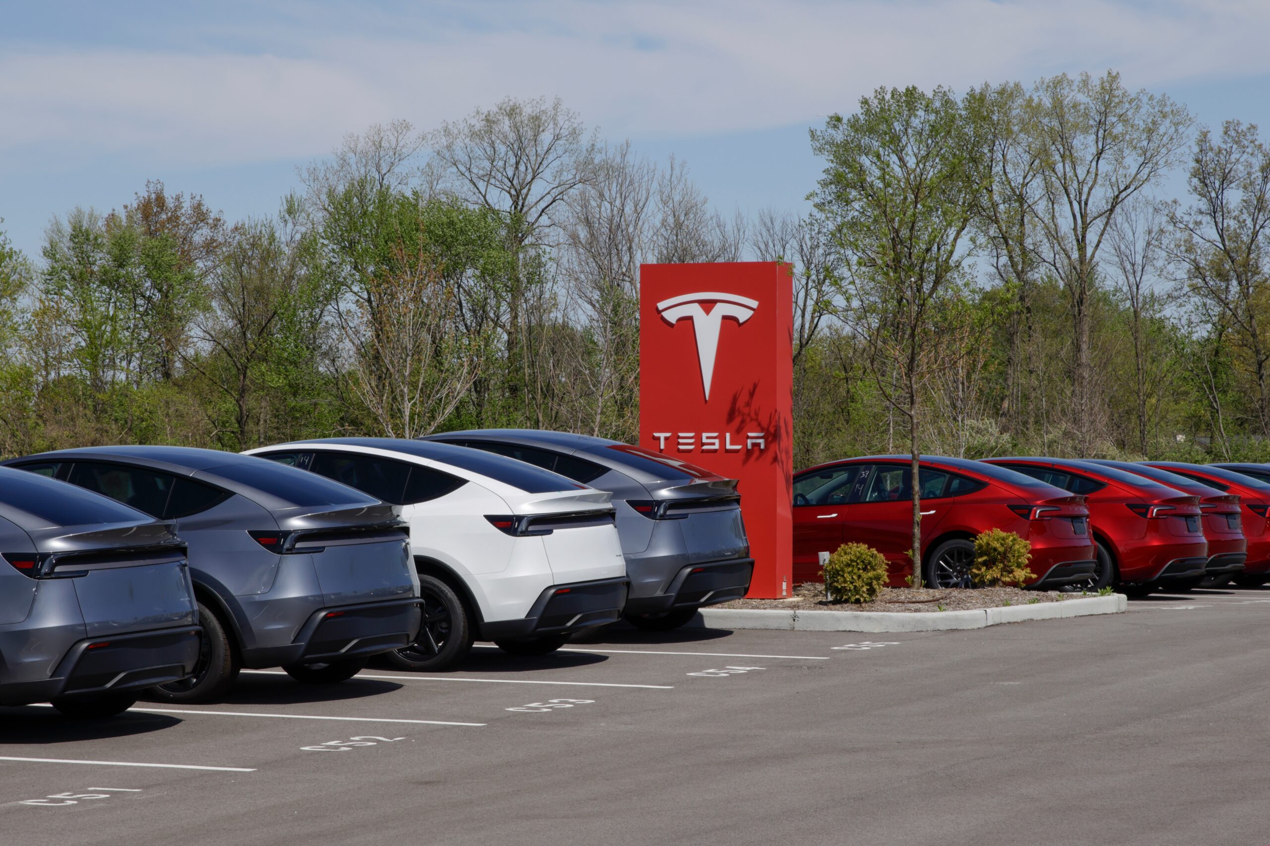 Tesla Model 3 and Tesla Model Y next to a Tesla logo