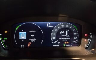 Digital car dashboard display showing various warning and status icons, including battery, engine, and driver-assist indicators, illustrating how to read dashboard symbols.