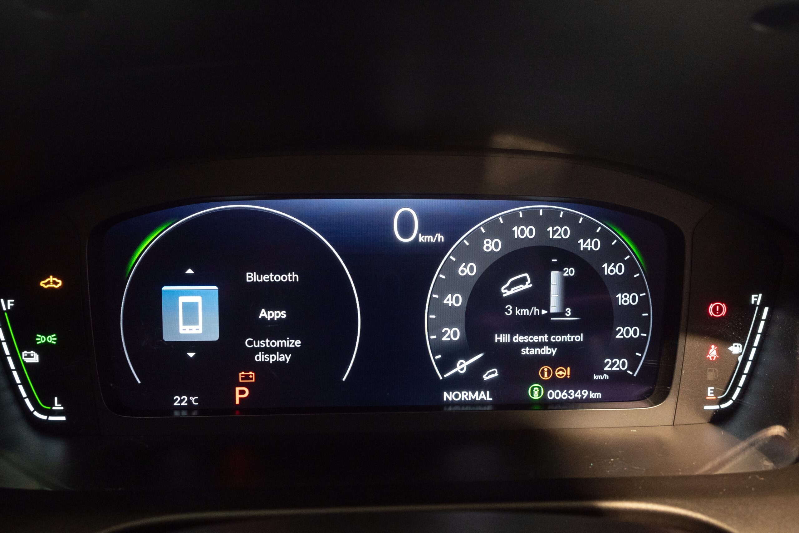 Digital car dashboard display showing various warning and status icons, including battery, engine, and driver-assist indicators, illustrating how to read dashboard symbols.